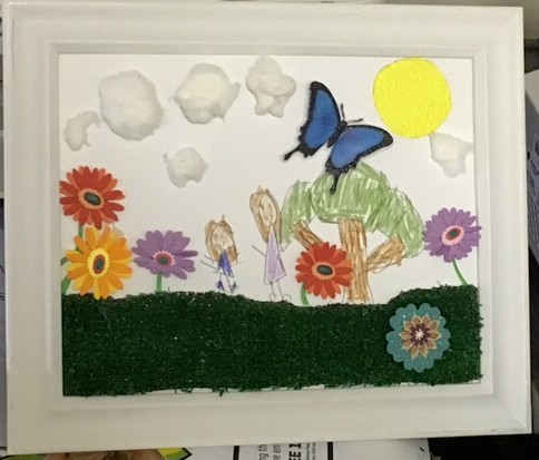 a drawing of the student and her mother with items such as butterfly stickers and cotton balls to add texture