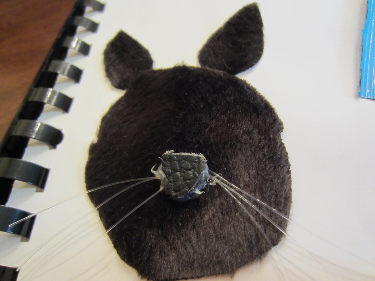 a mouse face with plush fur, whiskers, and a hard plastic nose