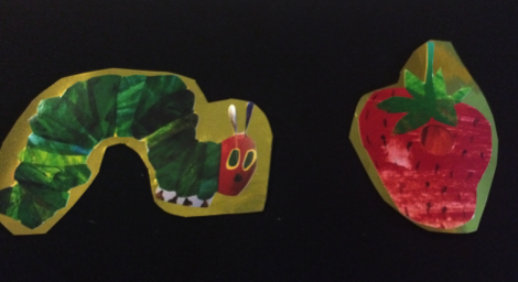 Images of caterpillar and strawberry cut out and mounted on gold mylar on black background