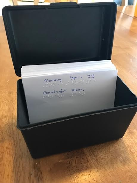 cards recording Liam's reading in a plastic box