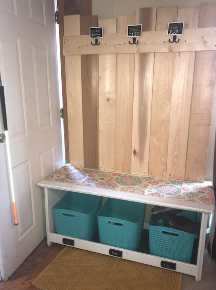 finished organization bench with hooks for coats, a hook for Liam's cane, and bins for shoes