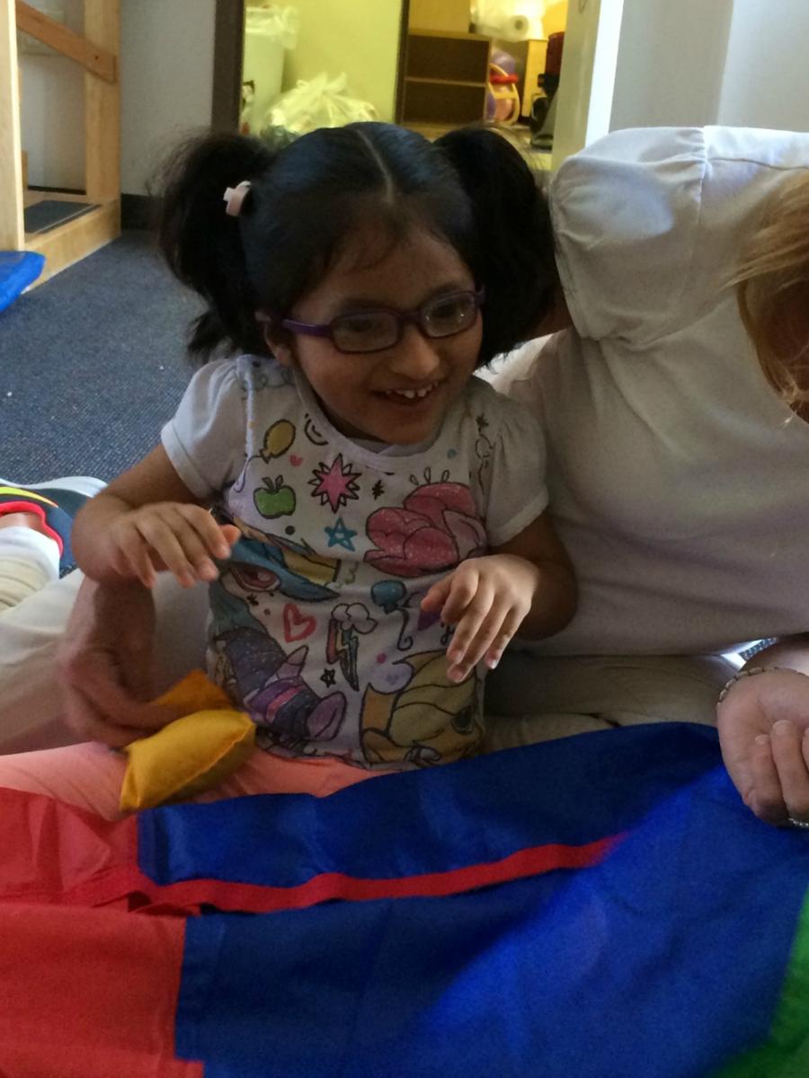 student playing with multicolored parachute