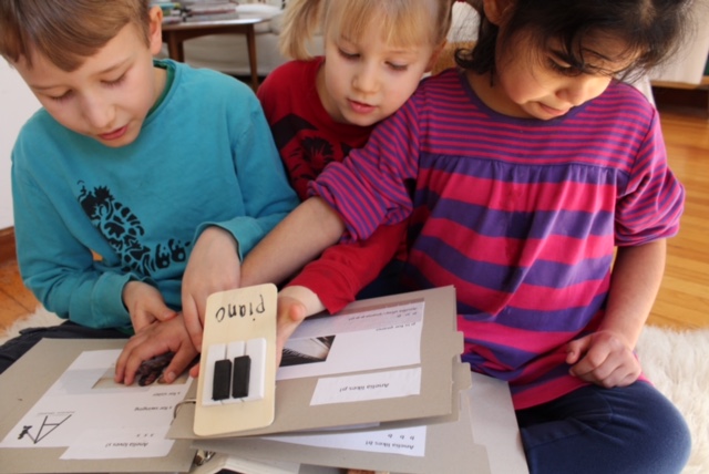 Anelia looks at the piano page with her brother and sister.