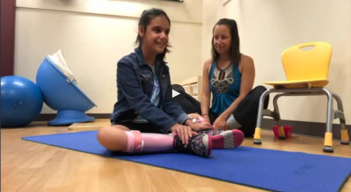 A student picks a pose with her yoga instructor