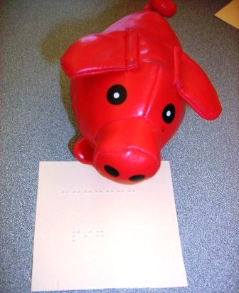 Small toy pig with braille word card