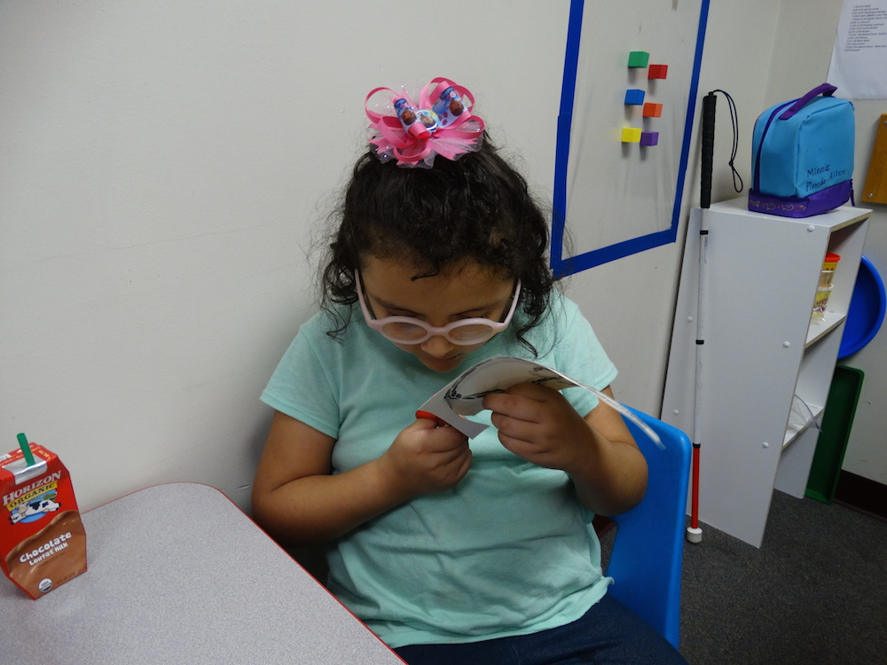 Click to view Student using scissors to cut badge for police letter