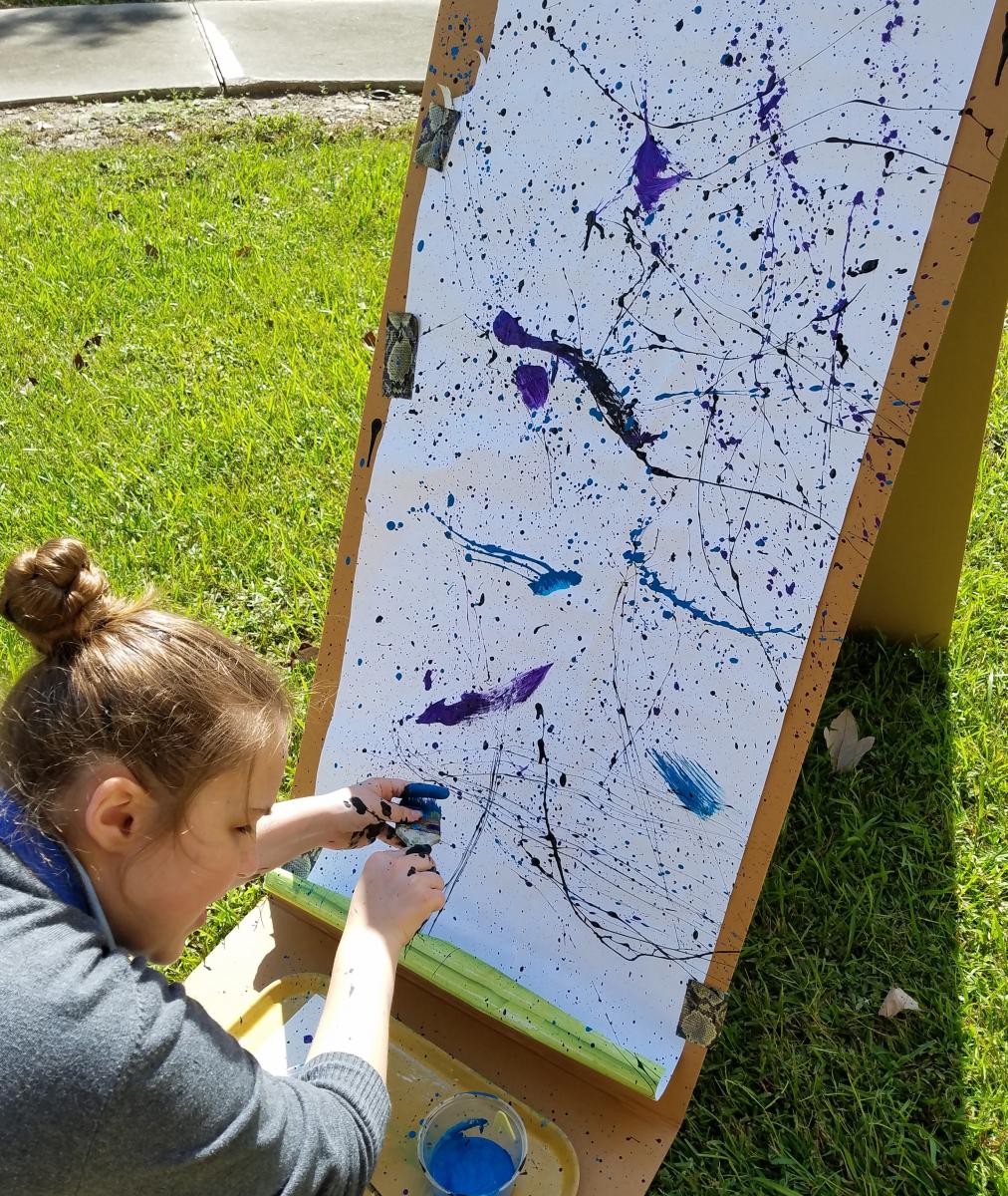 A girl experiments with the style of artist Jackson Pollock