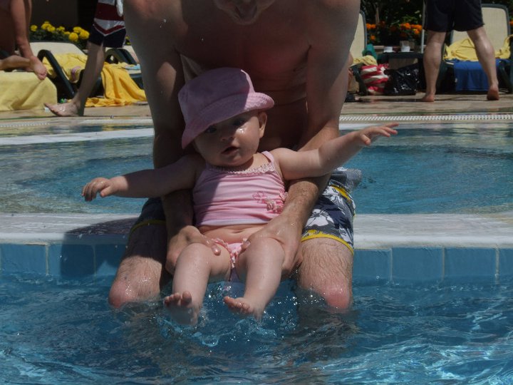 baby sitting by edge of pool