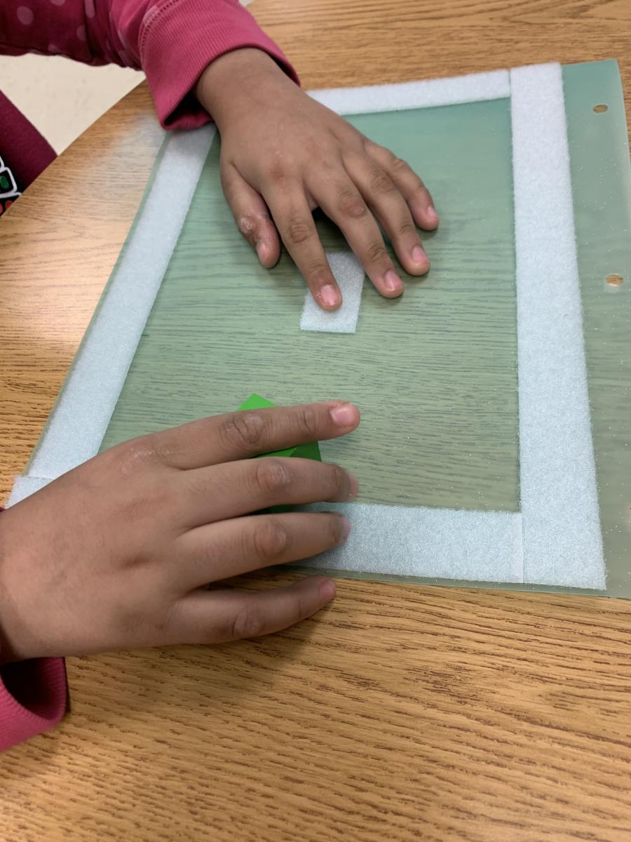 A student finds the Velcro in the center of the page.