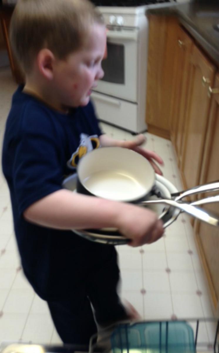 Young boy carrying pots and pans