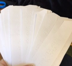 Brailled writing prompts held in a fan display a bunch of writing prompts written in braille, held in fan display