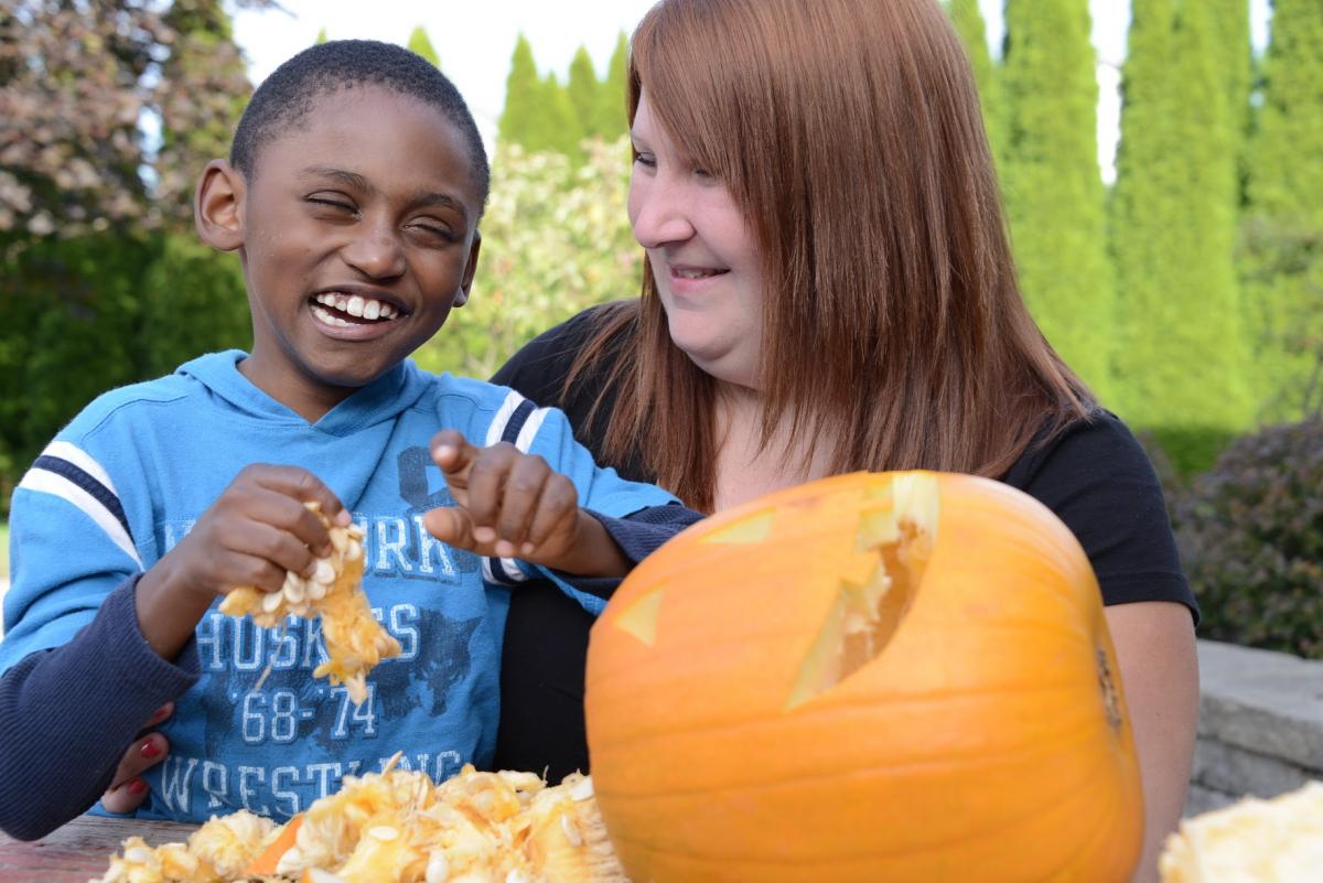 A child holds the insides of a pumpkin