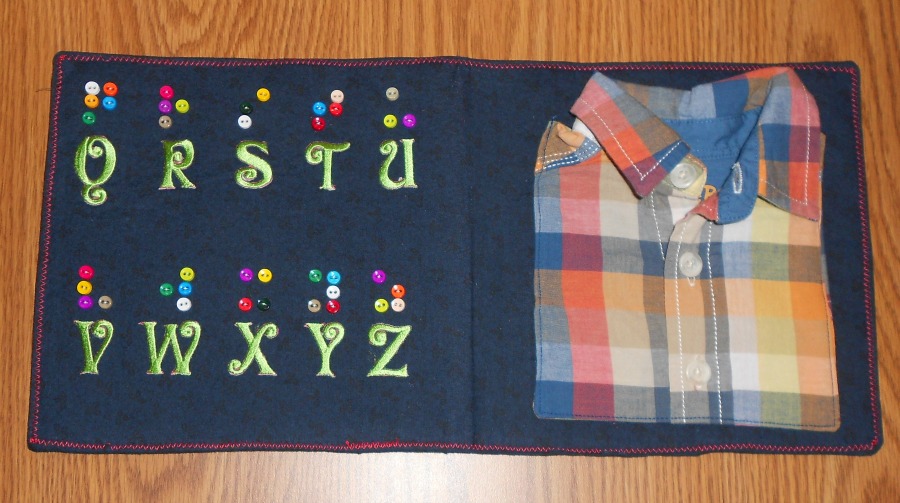 quiet book with alphabet letters and braille dots and a plaid shirt