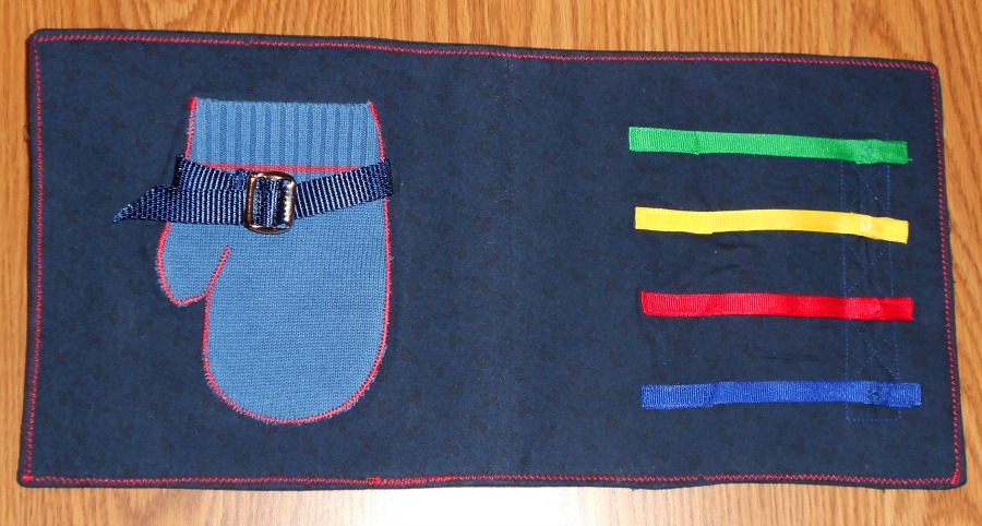 quiet book with tactile mitten and different color fabrics