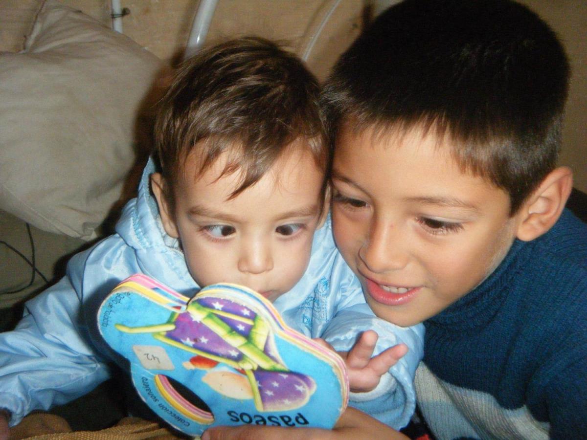 A young boy reads to his brother.
