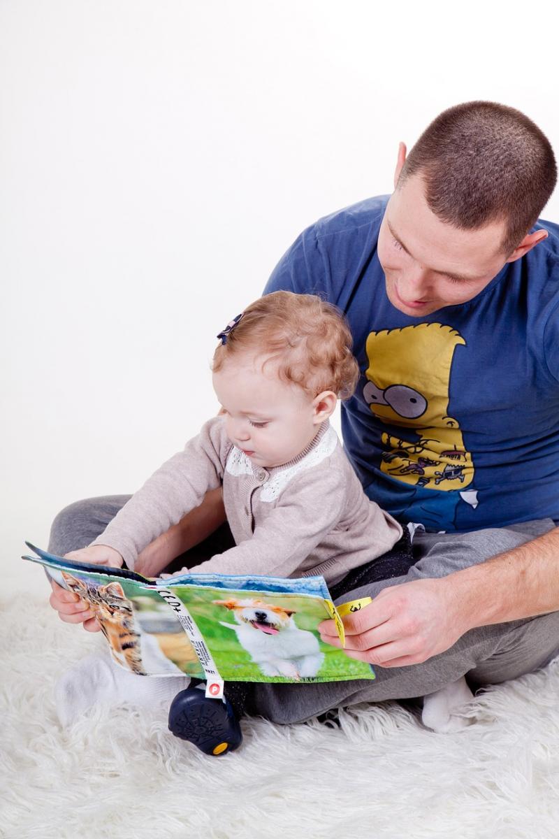 A father reads aloud to his daughter