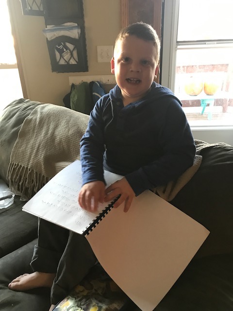 A boy reading his Halloween braille book.