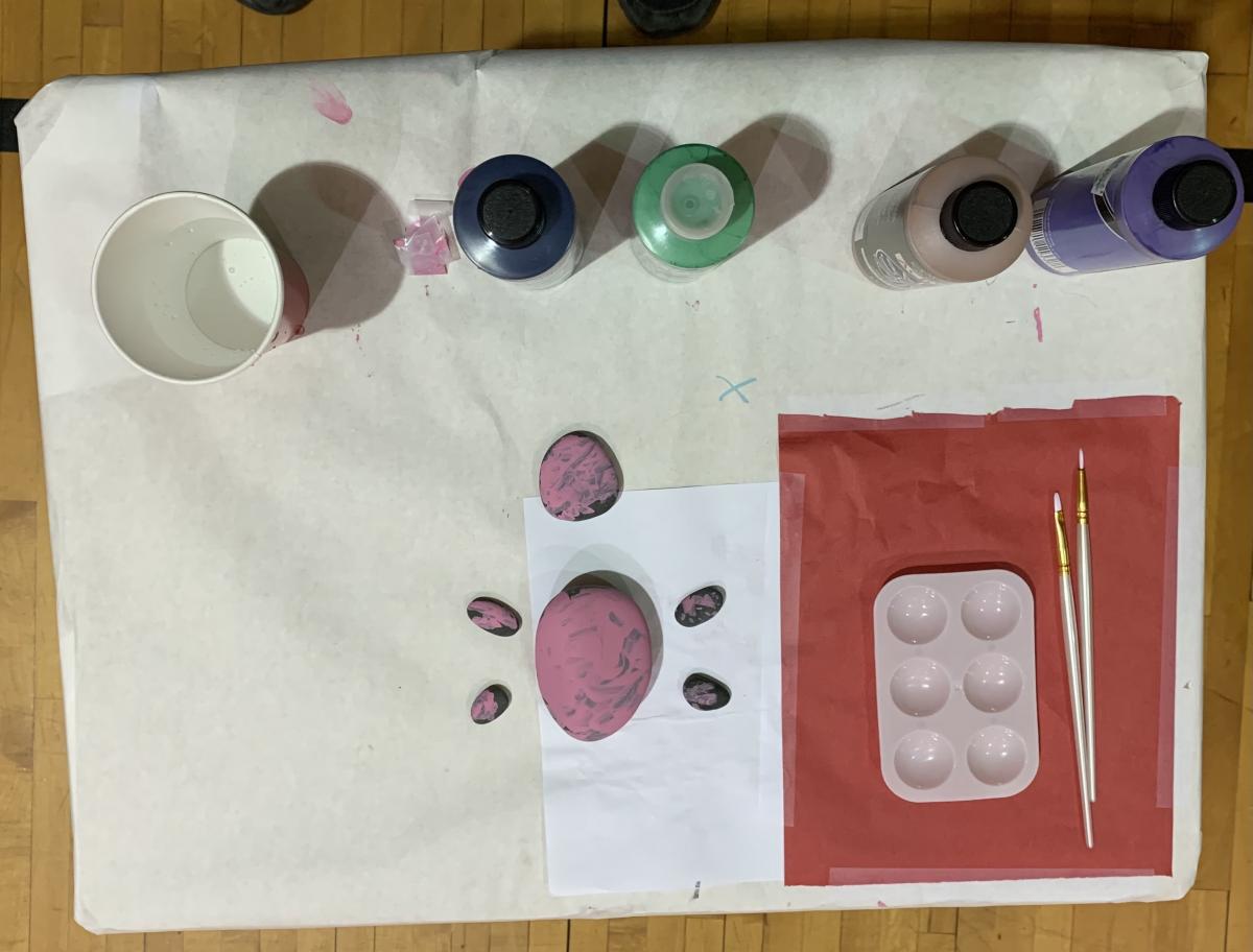Palette with bottles of paint, paintbrushes, and finished 