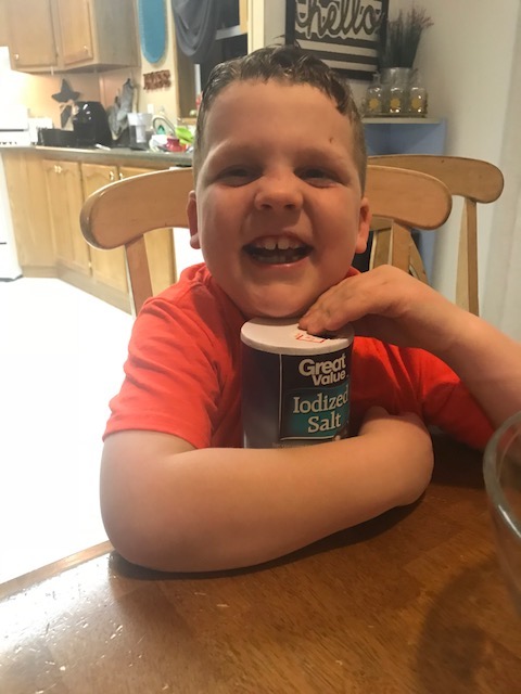 Liam smiles while holding the salt. Holding the salt