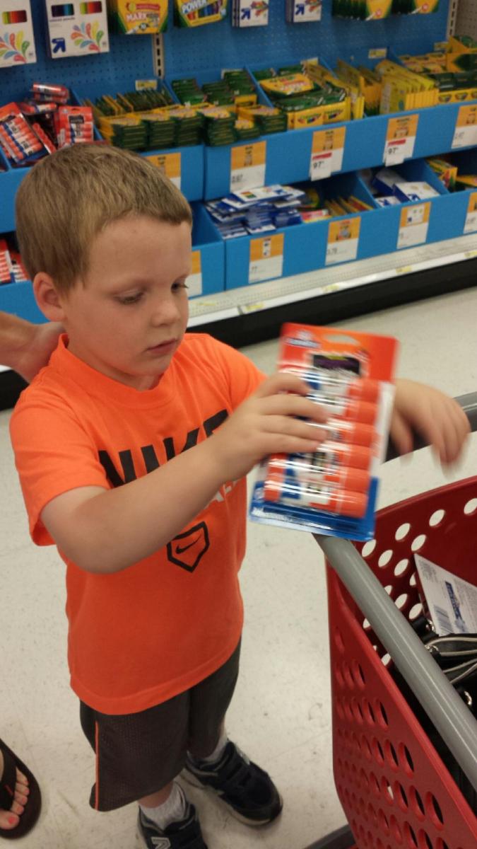 liam at the store holding glue sticks