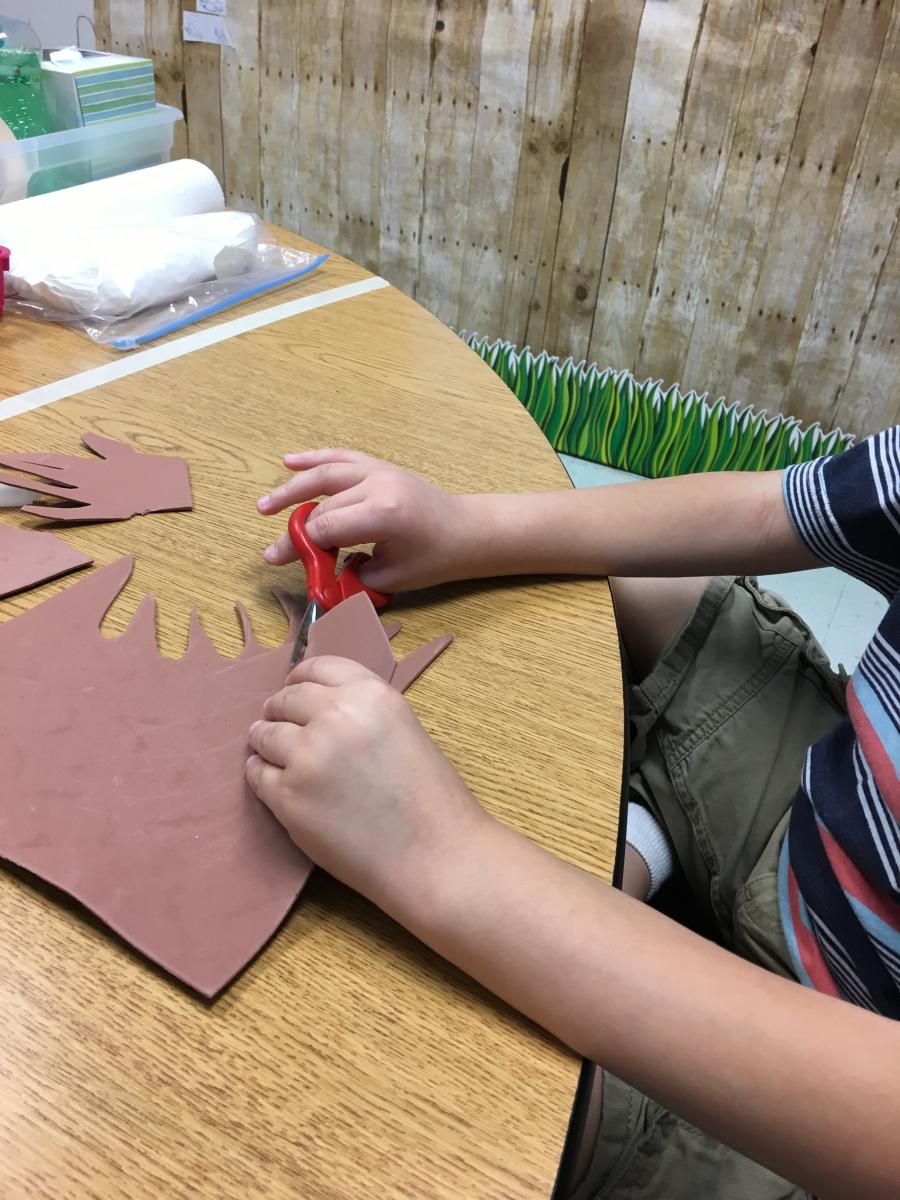 Using scissors to cut out handprint