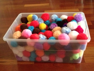 Sensory bin filled with cotton craft pom pom balls