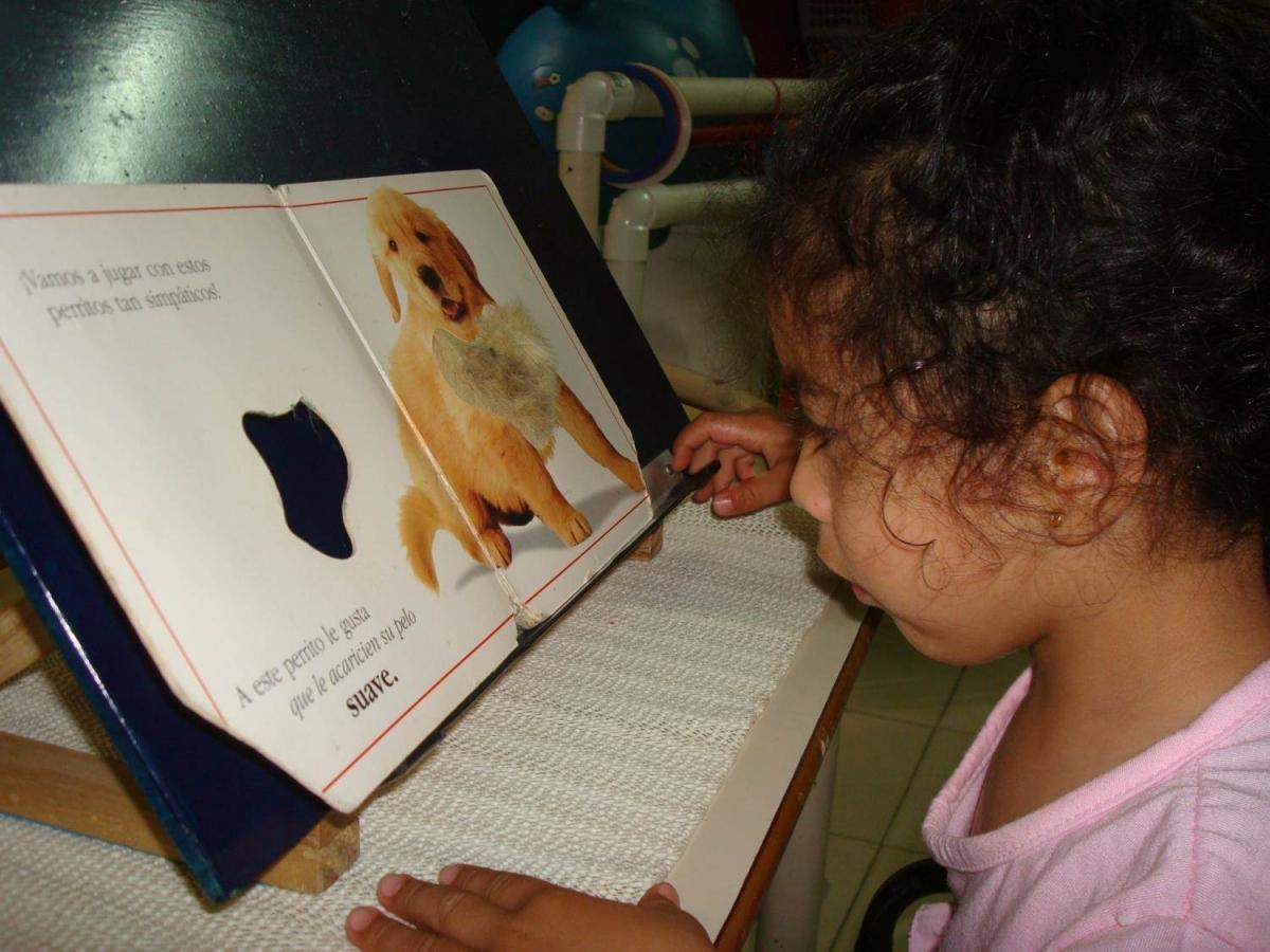 A young child uses a slant board.