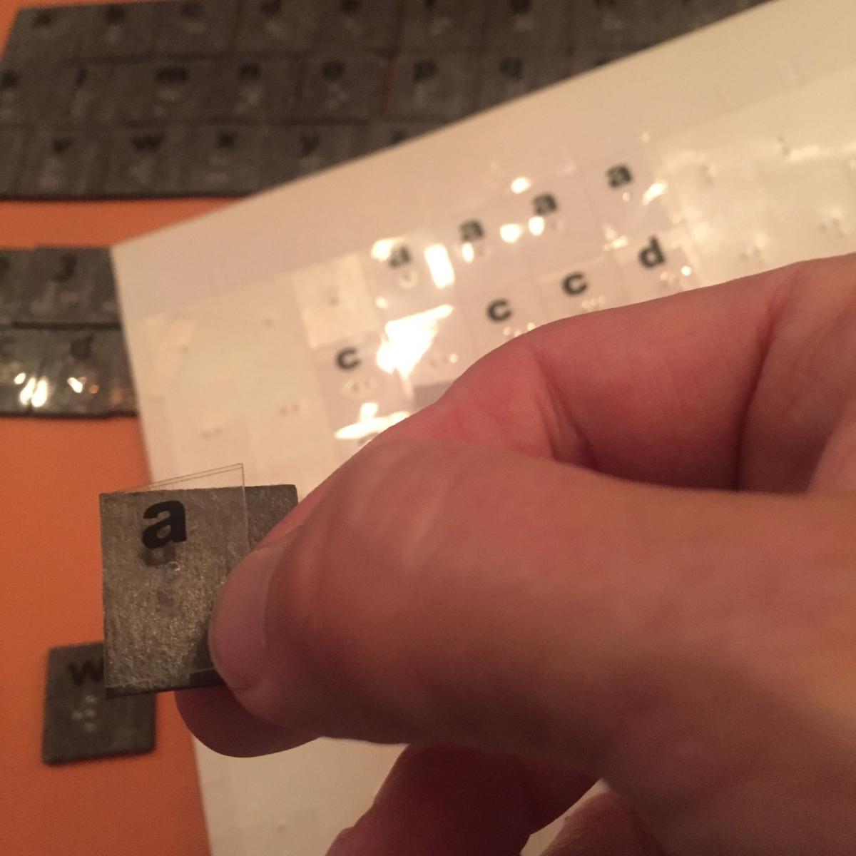 I'm holding letter sticker on right edge of magnet square, ready to stick it on I'm holding letter sticker on right edge of magnet square, ready to stick it on