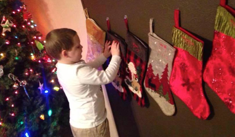 A boy reads braille on his Christmas stocking