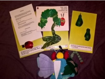 a bucket with items relating to the story The Hungry Caterpillar
