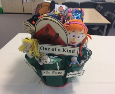a bucket containing dolls, and other items relating to the theme one of a kind