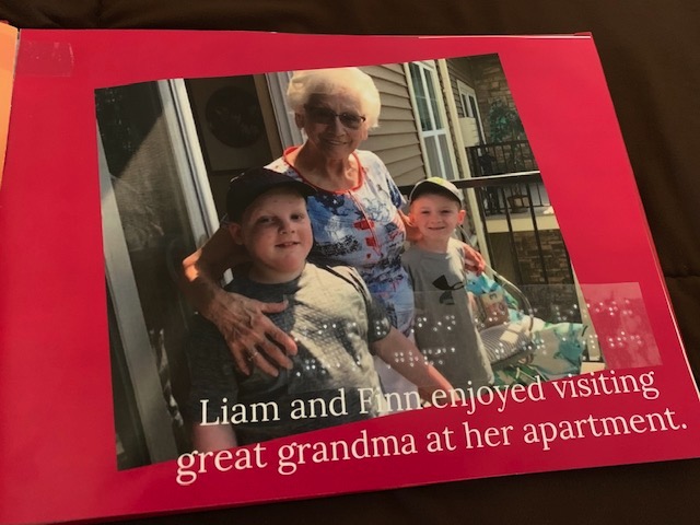 Page of photo book with two boys posing with their great grandmother
