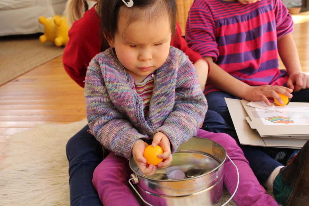 A young girl explores a ball.