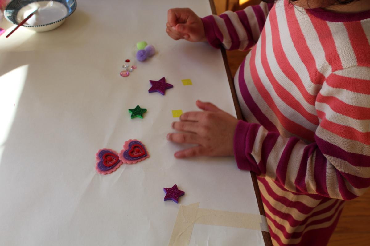 A young girl playing with different shaped foam stickers 