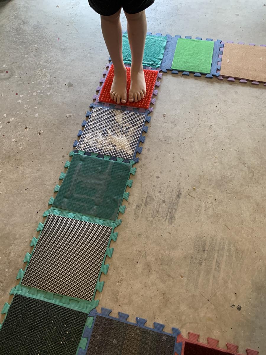 A child stands on a textured square.