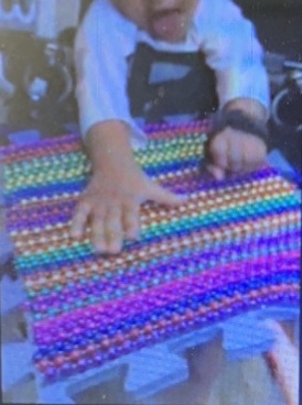 A young student feels the texture square with his hand. A young student feels the texture square