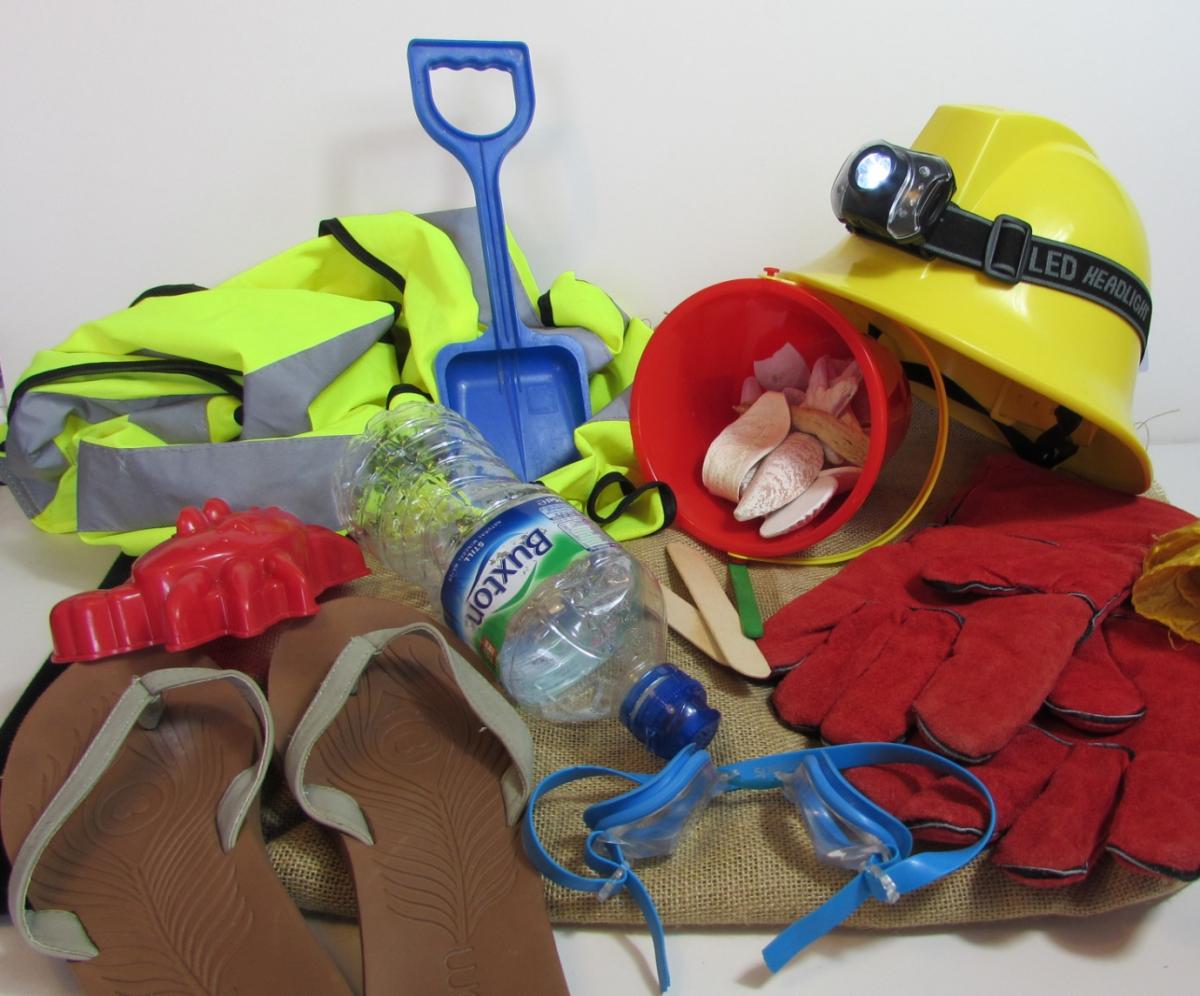 Traction Man's equipment including shovels, flip flops, a hard hat, a bucket, and gloves