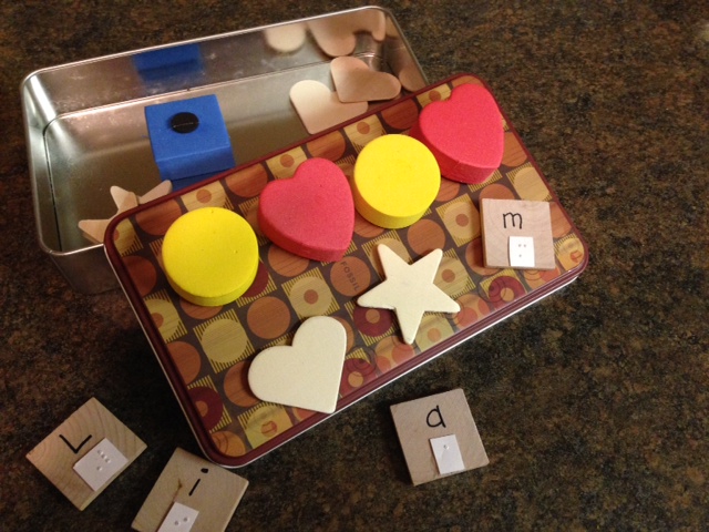 travel tin with shapes and letters with braille