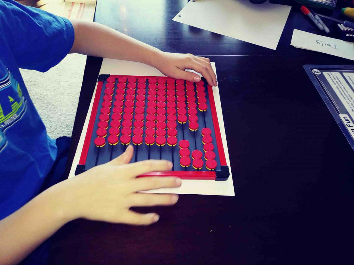 A student using the EZee Count abacus