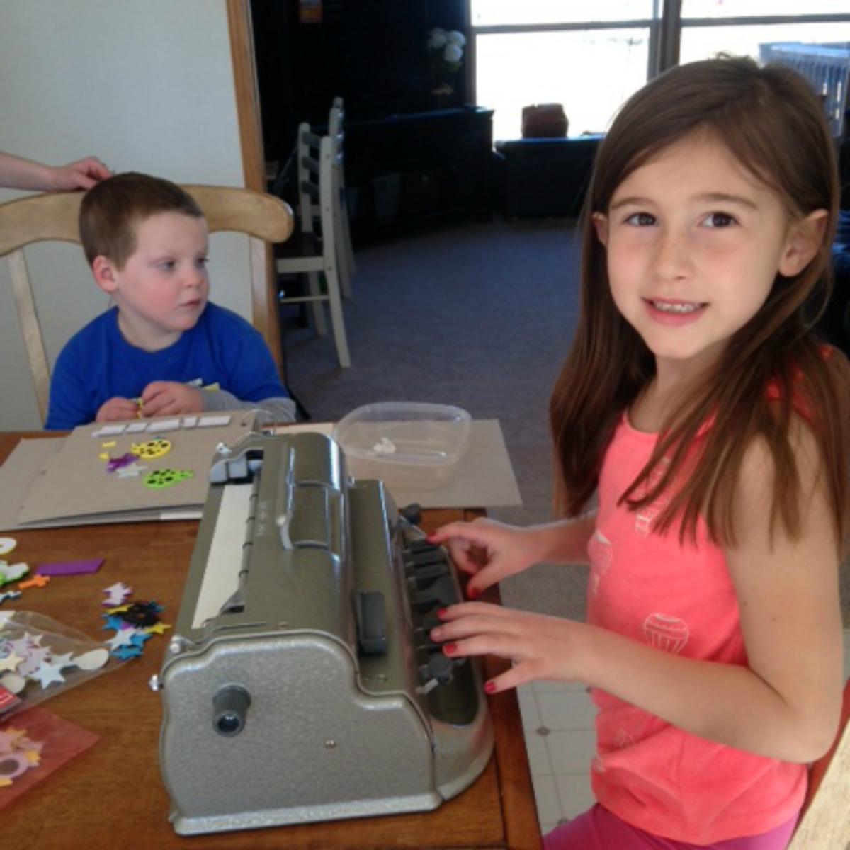 A girl uses a braillewriter