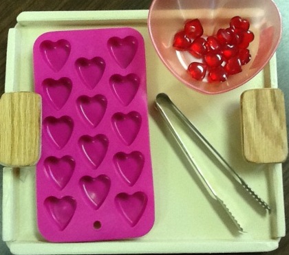 Tray with heart-shaped ice cube tray, red hearts, and tongs