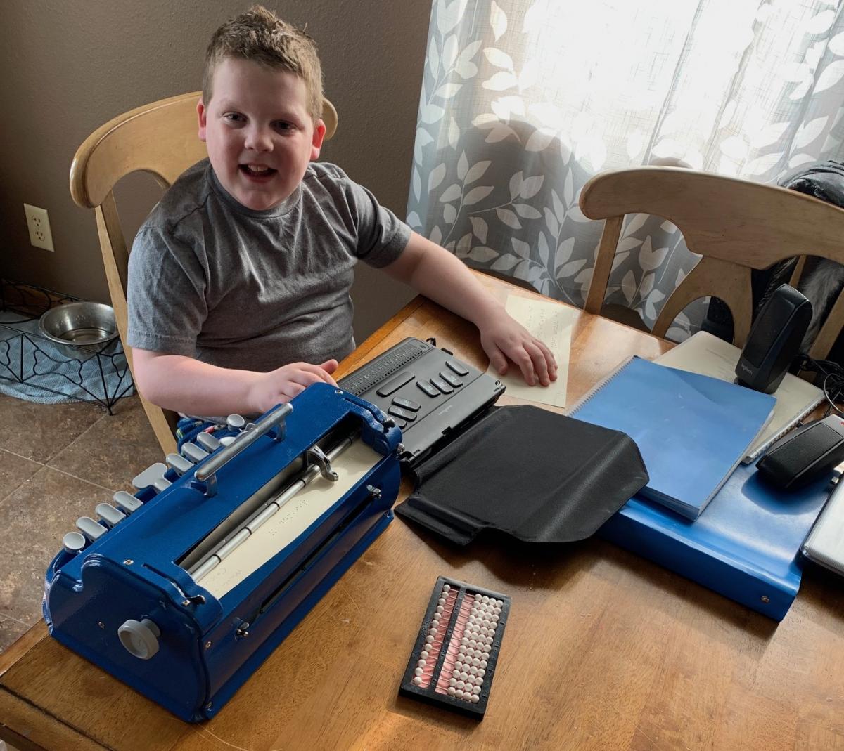 A boy does his braille work at home.