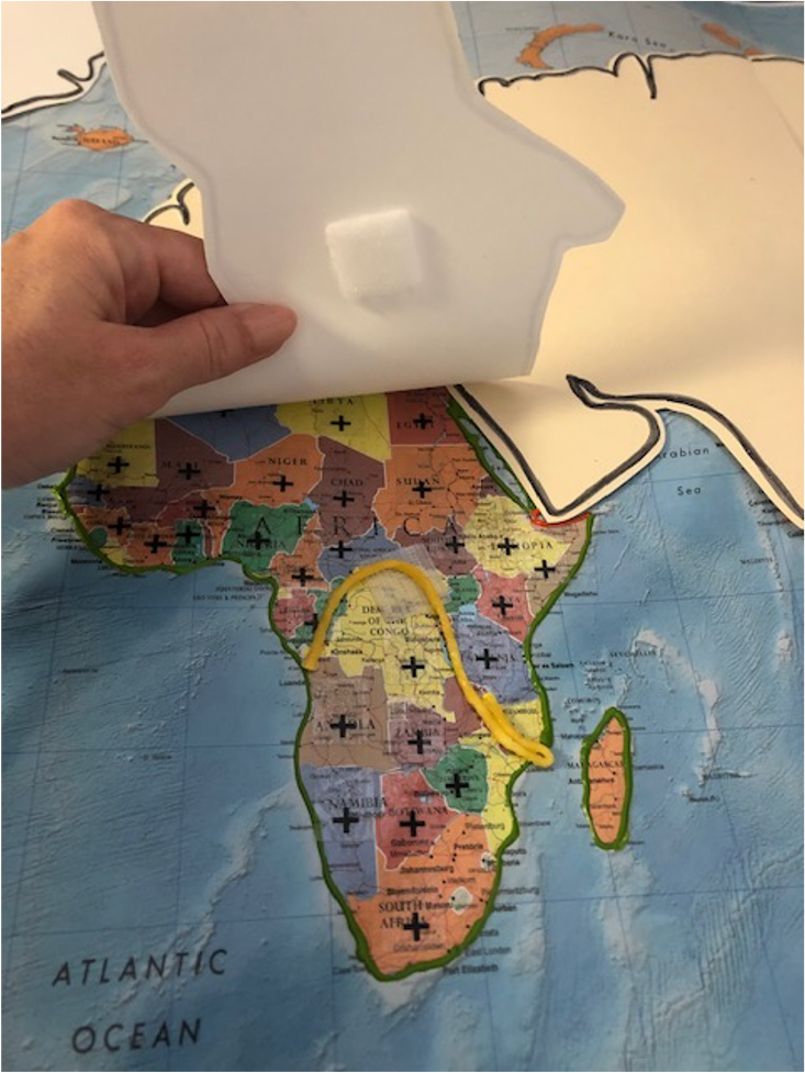 Map of African continent outlined in green with crosses marking each country. Yellow puff paint on map of Africa