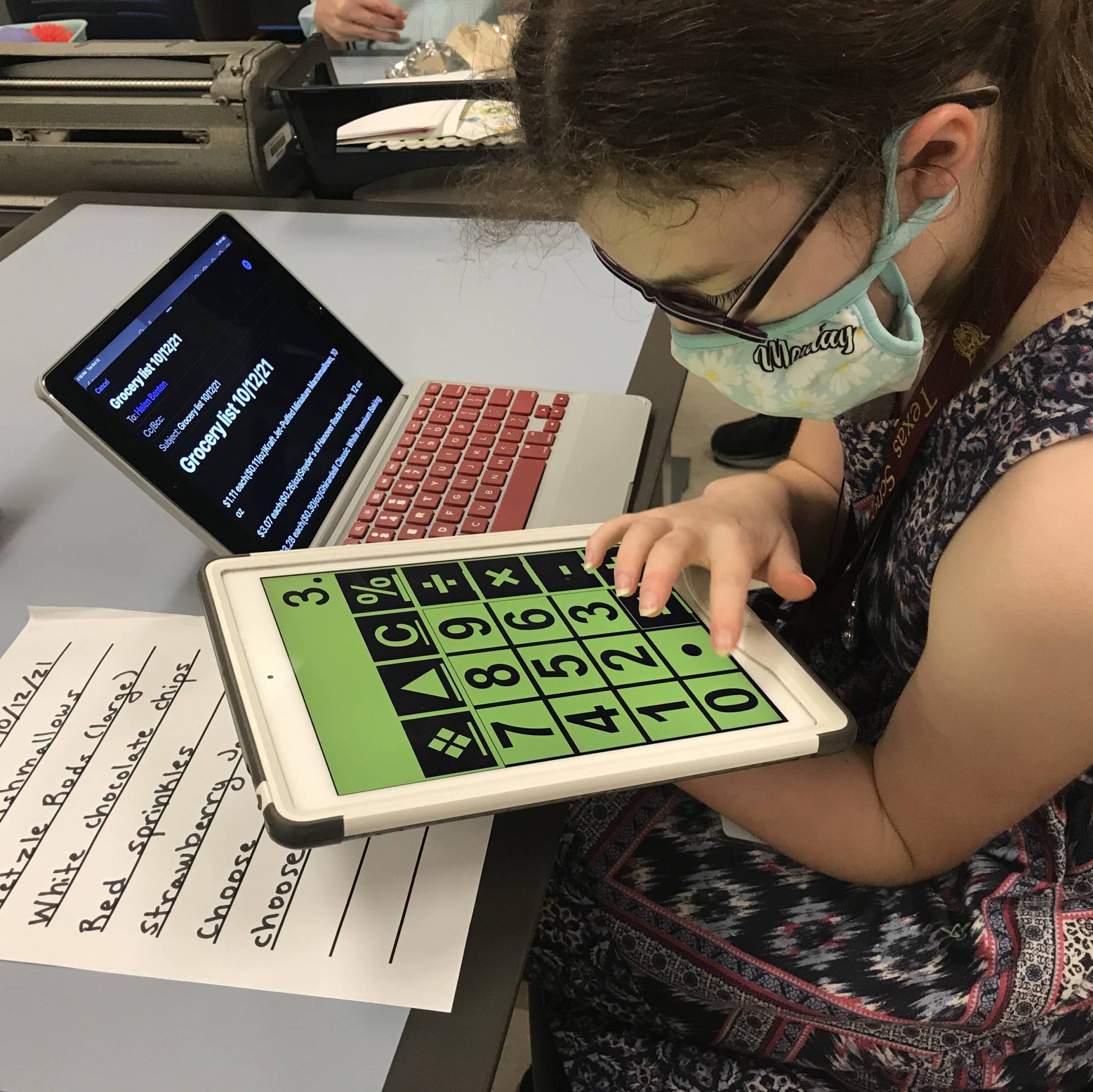 A girl uses a calculator on a tablet.