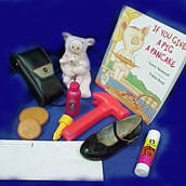 Story box items for “If You Give a Pig a Pancake” include a shoe, a glue stick, a hammer, and a small stuffed pig.