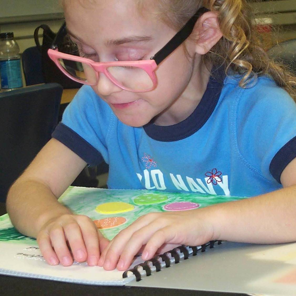  A girl reads a braille book