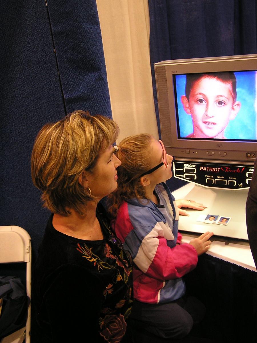 Haylee & her TVI look at an image of a boy on a closed circuit television.