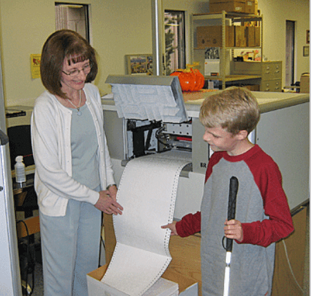 Seedlings creator Debra Bonde with a student by the braille production machine