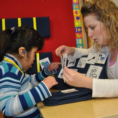 A woman and child are working on a tactile activity together.