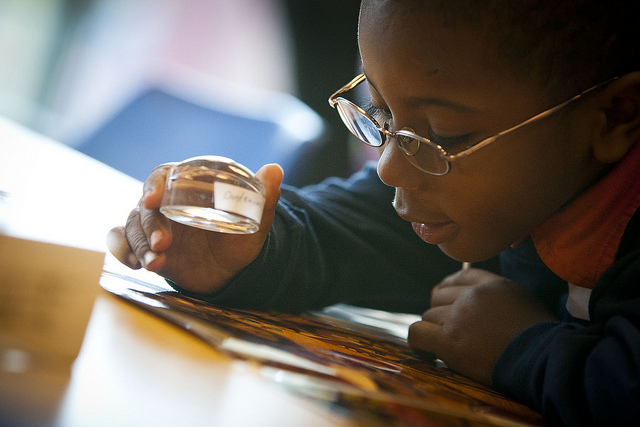 A student using a hand-held magnifier